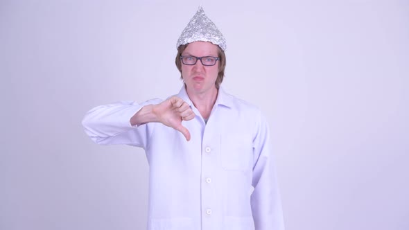 Stressed Young Man Doctor with Tinfoil Hat Giving Thumbs Down