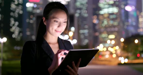 Businesswoman use of tablet computer at night