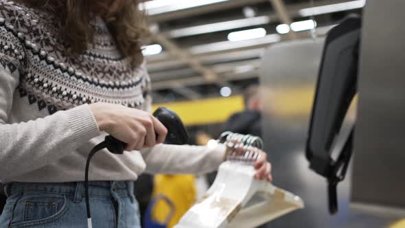 Young Brunette Woman Scans Home Goods Codes at Selfcheckout