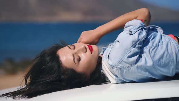 Portrait of a Girl Lying on a Car at the Beach