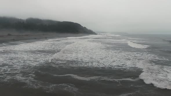 Drone moves over foaming waves and mountains in Sharp Point at Dry Lagoon State Park,California,USA