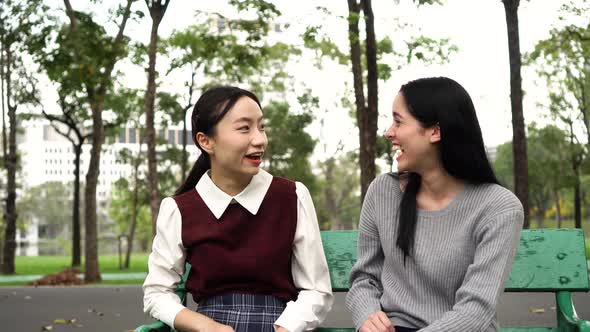 Two Female Women Friends Talking at Public Park and Raising Hands Together