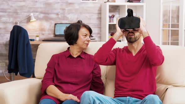 Nephew Teaching His Grandmother How To Use Virtual Reality Headset