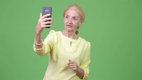 Beautiful Happy Senior Businesswoman Video Calling with Phone