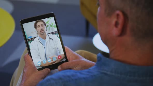 Senior man having a video chat on his digital tablet at home