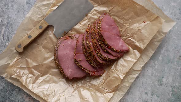 Delicious Peppered Roast Beef Pastrami Slices on Paper with Grains of Coloured Pepper