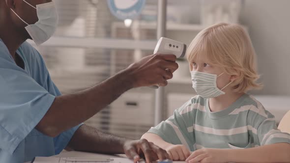 Doctor Measuring Temperature of Little Boy