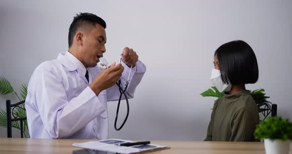 Doctor using stethoscope listen to the heart of girl in the clinic