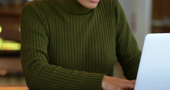 Female executive using laptop on desk 4k