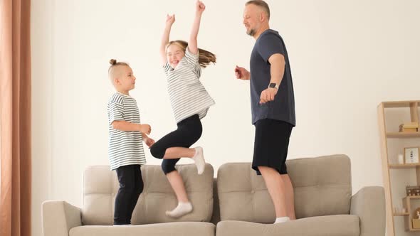 Dad Plays with the Children They Jump on the Couch