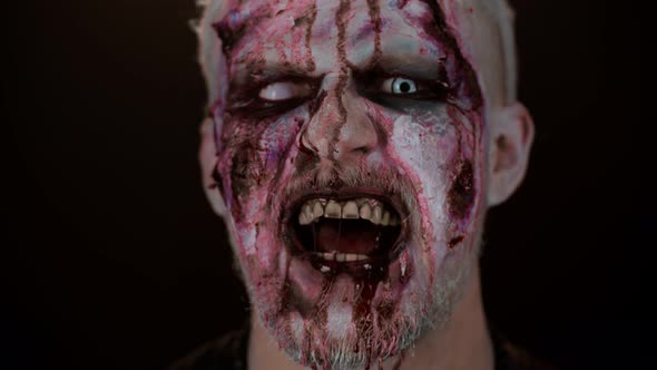 Zombie Man Face Makeup with Wounds Scars and White Contact Lenses Blood Flows and Drips on Face