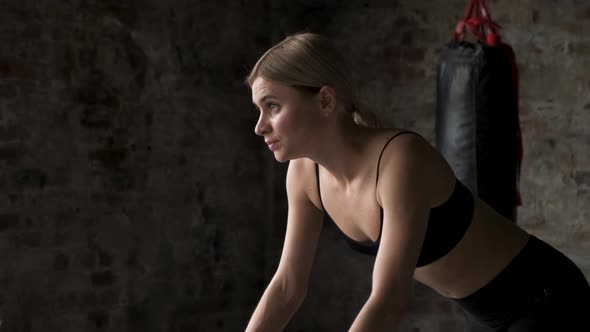 Young girl running on the exercise bike in the sport gym.