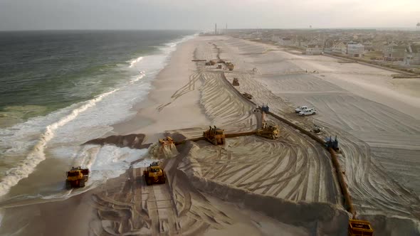 Fast fly by aerial pull back of the large scale dredging operation of a long pipe laying along the b