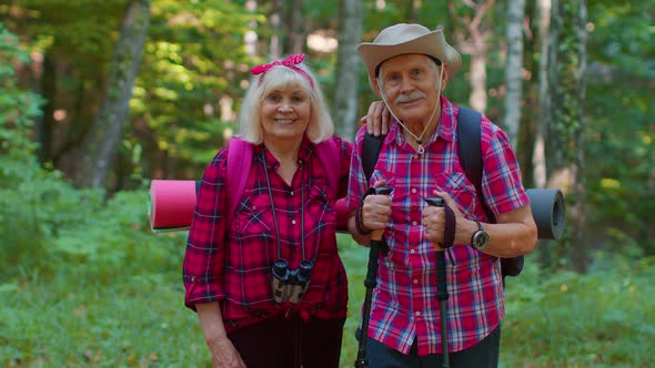 Senior Old Grandmother Grandfather Tourists Enjoying Walking Hiking with Backpacks in Summer Wood