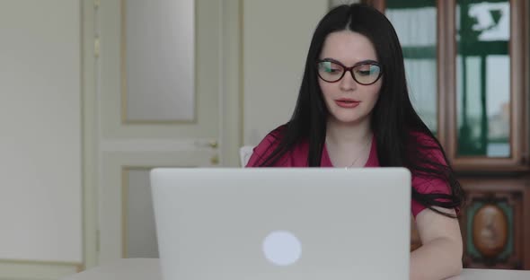 Female Nurse in Glasses Conducts Online Counseling Online on Laptop at Home