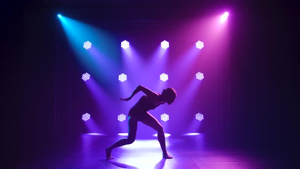 Professional Ballerina in Black Bodysuit Gracefully Dancing Ballet in Dynamic Spotlights and Smoke