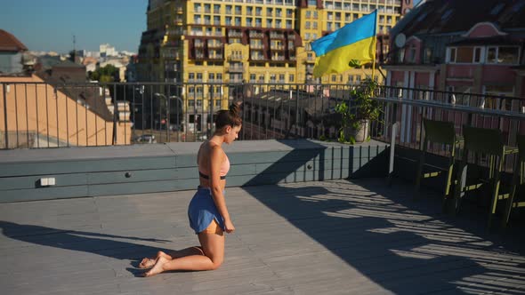 Young Woman Practicing Yoga on the Roof of a Building