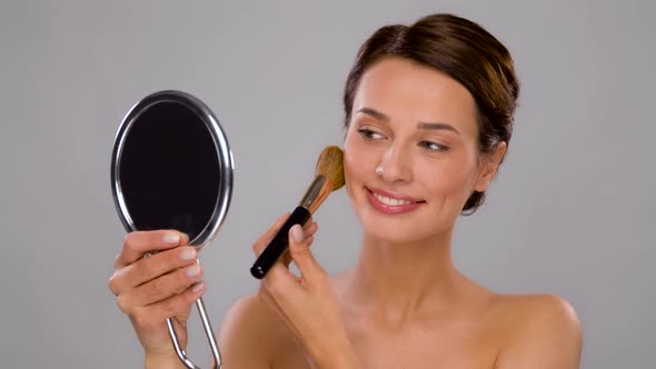 Beautiful Woman with Mirror and Makeup Brush