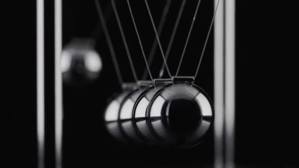 The balls of a Newtons Cradle colliding in slow motion alt