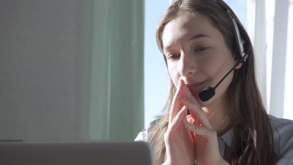 Serious Call Center Operator in Wireless Headset Talking with Customer Close Up