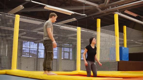 Trainer By Trampolining Is Teaching Young Woman To Jump in a Gym