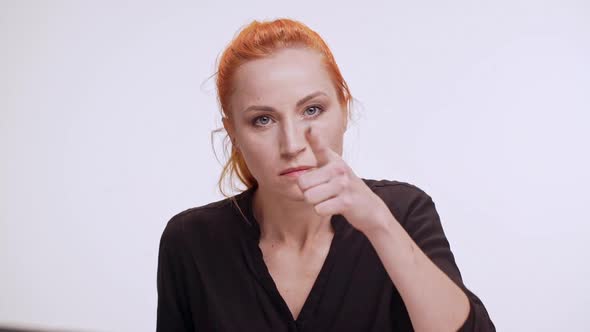 Strict Middleaged Caucasian Woman with Colored Orange Hair Pointing Finger Standing on White