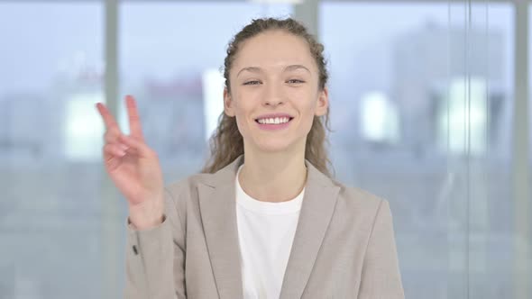 Portrait of Successful Young Businessman Showing Victory Sign 