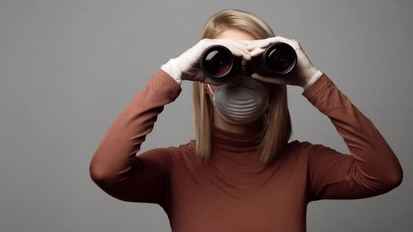 blonde lady in face mask with binoculars