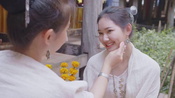 Two Teenage Girls In Thai Traditional Dress Applying Make Up