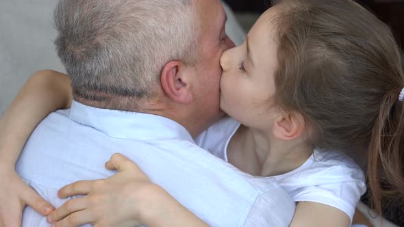 Family Portrait of Mature Father and Little Blonde Daughter Hugging at Home While Celebrating Father