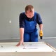 A Man a Handyman in a Blue Jumpsuit is Assembling a Table in Closeup - VideoHive Item for Sale