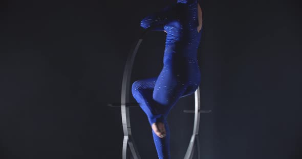 Brunette Woman in Blue Costume is Doing Gymnastics in Low Lighting
