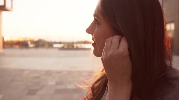 Young attractive business woman sitting outdoor on the bench and using smartphone.