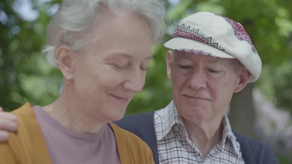 Portrait of a Mature Couple in Love Sitting on a Bench in the Park