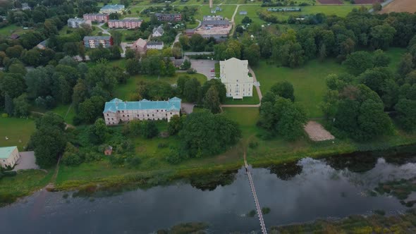 Mezotne Palace and Park With Fountain in Latvia. Lielupe River With Ponton Bridge Aerial 4K