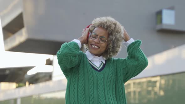 Young African Woman Dancing to Playlist Music Outdoor