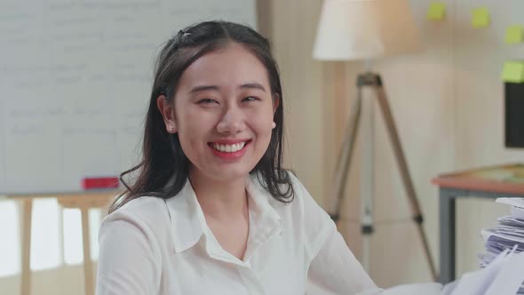 Close Up Of Asian Woman Smiling To Camera While Working With Documents At The Office