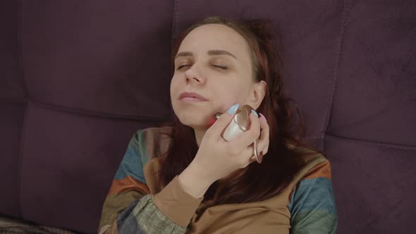 A Woman with Problematic Skin Using Face Electric Massager