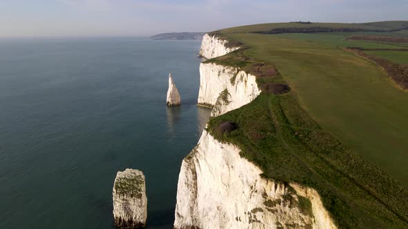 Drone flying on edge of Old Harry Rocks Cliffs, Purbeck island in Dorset. Aerial tilt-up