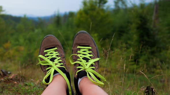 Women's Legs In Hiking Sports Boots Against The Backdrop Mountains The Girl Sits Resting Close Up