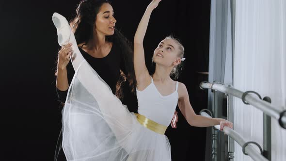 Concentrated Teen Girl Learning Ballet Dance in Studio with Female Trainer Teacher Help Stretching