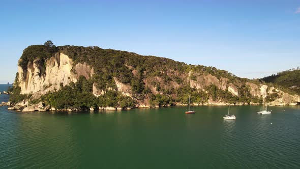 Scenic pan across small bay with yachts in Coromandel Peninsula, NZ