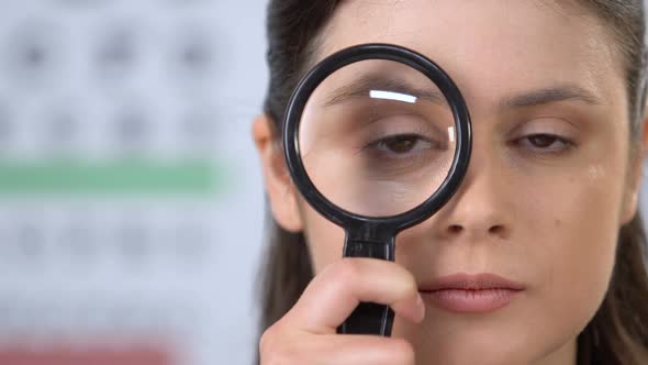 Female Looking Through Magnifying Glass, Trying to Concentrate, Vision Check