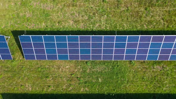 Flight Over a Field of Solar Panels in Sunny Summer Day