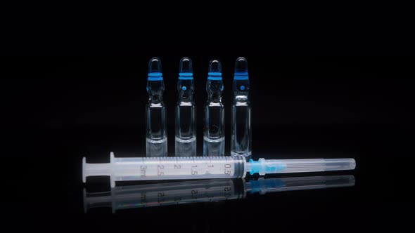 Closeup of Syringe and Ampoules with Vaccine Against Coronavirus