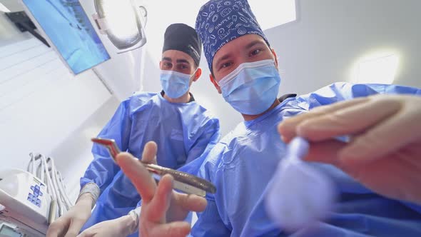 Professional dentist treats tooth. Assistant helps stomatologist in dental clinic.