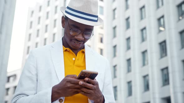 Black man in yellow t shirt and white suit communicates online