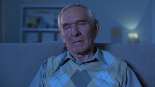 Elderly Man Sleeping on Sofa at Home, Evening Relaxation, Tiredness, Close-Up