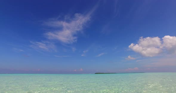 Luxury drone travel shot of a sunshine white sandy paradise beach and blue water background in vibra