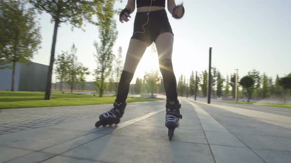 Beautiful Young Woman On Rollerblading In Park At Sunrise